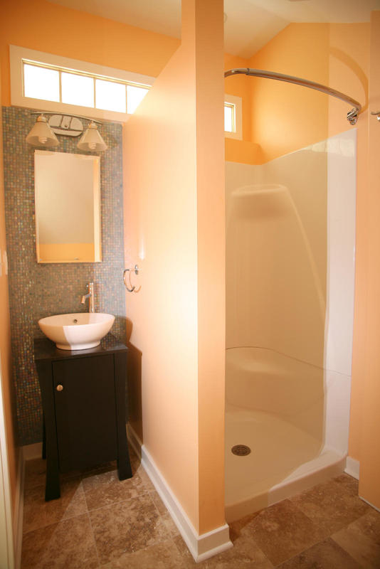 High mosaic tile makes the sink area feel larger. Transom window brings in afternoon light.